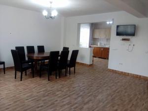 a dining room with a table and black chairs at Vila Lorin in Cristeştii Ciceiului