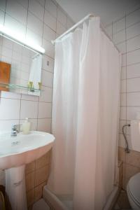 baño con lavabo y cortina de ducha en SAGA Pension, en Gythio
