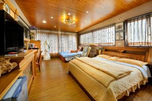 a bedroom with a large bed and a flat screen tv at Jinge Guest House in Jiji