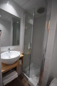 a bathroom with a shower, sink, and tub at Best Hotel Bordeaux Sud in Villenave-dʼOrnon
