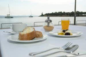 a table with a plate of bread and a glass of orange juice at SAGA Pension in Gythio