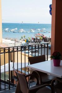 a view of the beach from a balcony with a table and chairs at Acitrezza B&B in Acitrezza