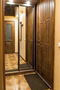 リヴィウにあるCozy Apartment in the City Centerの木製のドアと鏡付きの廊下が備わる客室です。