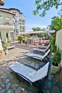 a row of chaise lounge chairs on a patio at Hotel Amfora in Saints Constantine and Helena