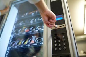 a person holding a capsule in front of an oven at Best Hotel Bordeaux Sud in Villenave-dʼOrnon