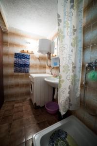 a small bathroom with a tub and a sink at Eko House Dobrenica in Bihać +61 photos