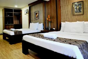 Habitación de hotel con 2 camas con sábanas blancas en Altamare Dive and Leisure Resort Anilao, en Mabini