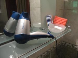 a glass counter top with a hair dryer and a comb at Diplomat ApartHotel in Kyiv