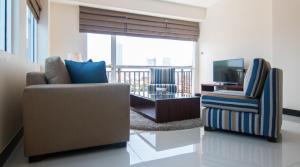 a living room with a couch and a chair and a television at Rococo Residence in Colombo