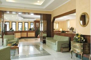 a lobby with couches and chairs in a building at American Hotel in Pozzuoli