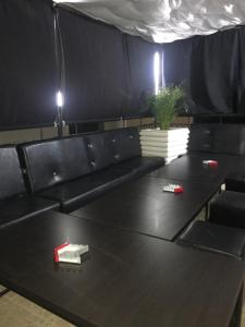 a black couch with a book on a table at Vila Albertino in Eforie Nord