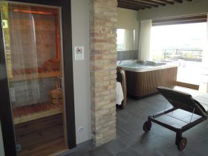 uma casa de banho com um chuveiro, uma cadeira e uma banheira em agriturismo Piccolo Albero em Loreto Aprutino