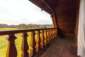 einen Balkon einer Hütte mit Blick auf ein Feld in der Unterkunft Kaukiškė in Antaiksnė