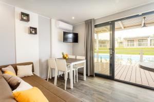 a living room with a couch and a table with chairs at Mobile Homes Camping Santa Marina, Lanterna in Poreč