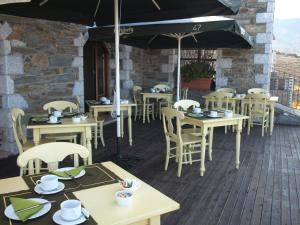 a restaurant with tables and chairs on a deck at Porto Mani Suites in Kyparissos