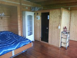 a bedroom with a bed in a room with wooden walls at Koningsheim in Colijnsplaat
