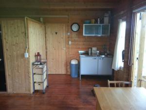 a kitchen with a table and a clock on the wall at Koningsheim in Colijnsplaat +5 photos