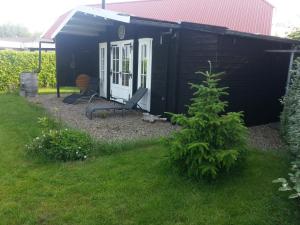 a black shed with a chair in a yard at Koningsheim in Colijnsplaat