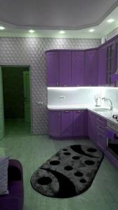 ウラジカフカスにあるVip Kvartira V Stile Loftのキッチン(紫色のキャビネット、大きなラグ付)