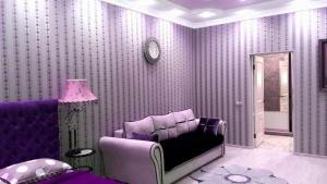 ウラジカフカスにあるVip Kvartira V Stile Loftの紫色の部屋(ソファ、鏡付)