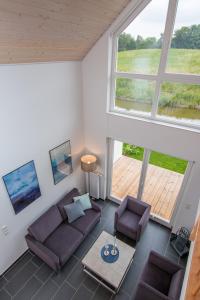 ein Wohnzimmer mit 2 Sofas und einem großen Fenster in der Unterkunft Ferienhaus Hafenkante mit Sky in Nordhorn