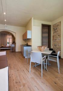 Il comprend une cuisine et un salon avec une table et des chaises. dans l'établissement La Bellavita Del Garda Luxury Apartments, à San Felice del Benaco