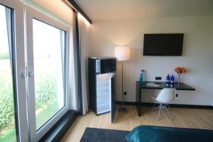 um quarto de hotel com uma secretária e uma janela em MN Hotel by WMM Hotels em Mindelheim
