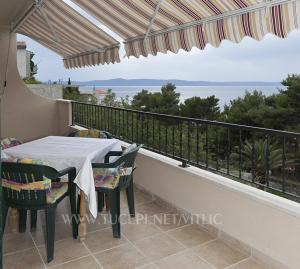 a table and chairs on a balcony with a view at VILA MILENKA Apartmani Drago in Tučepi