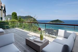 サン・セバスティアンにあるVilla Baena by FeelFree Rentalsの白い家具付きのバルコニーから海の景色を望めます。