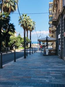 a sidewalk with tables and umbrellas on a beach at Sanremo Home Loft in Sanremo