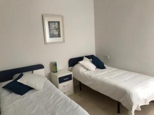 1 dormitorio con 2 camas y una foto en la pared en Apartamento centro Sevilla, en Sevilla