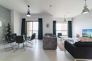 salon z kanapą, stołem i krzesłami w obiekcie Icon Casa Living - Rimal 6-JBR Marina view w Dubaju