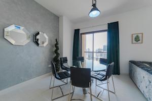 a dining room with a glass table and chairs at Icon Casa Living - Rimal 6-JBR Marina view in Dubai