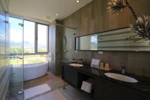 bagno con 2 lavandini, vasca e doccia di Splendi Villa a Città Vecchia di Hengchun