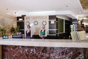 two women standing at a reception counter in a lobby at Lisova Pisnia Resort Hotel in Truskavets