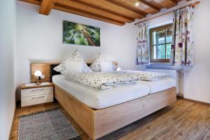 Schlafzimmer mit einem Bett mit einem Holzrahmen und einem Fenster in der Unterkunft Appartements Hochödlehen in Schönau am Königssee