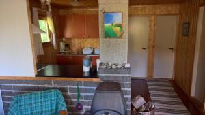 a kitchen with a counter top and a kitchen with a counter top at Skogheim Two-Bedroom Cottage in Birkeland +3 photos