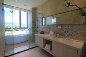 a bathroom with a tub and a sink and a mirror at Splendi Villa in Hengchun South Gate