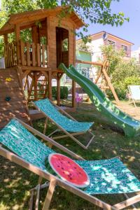 a playground with a watermelon on a slide and two chairs at Apartamenty Przystań in Międzyzdroje
