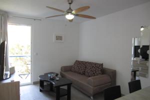 a living room with a couch and a ceiling fan at Apartman Valinor in Miholašćica