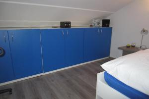 a bedroom with blue cabinets next to a bed at Apartman Valinor in Miholašćica