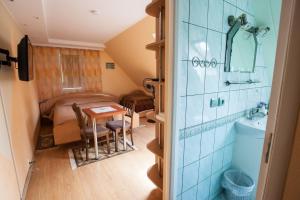 una piccola camera con bagno con lavandino e tavolo di Žvejo namas a Nida