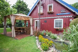 a red house with a deck and a gazebo at Žvejo namas in Nida