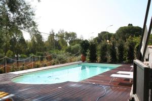 a swimming pool on top of a wooden deck at Avocado B&B Beyond in Giardini Naxos