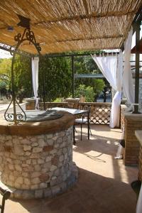 un patio de piedra con una mesa y una pared de piedra en Avocado B&B Beyond, en Giardini Naxos