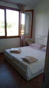 a bedroom with two beds and two windows at Il Chiosco Giallo in Capalbio