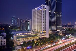 un grand bâtiment dans une ville la nuit avec la circulation dans l'établissement JS Luwansa Hotel & Convention Center, à Jakarta