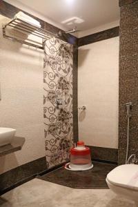 a bathroom with a shower and a toilet and a sink at Hotel Varanasi Inn in Varanasi