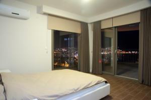 Un dormitorio con una cama y vistas a la ciudad. en Pine City Residence, en Kusadasi