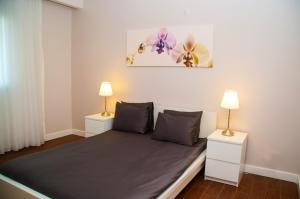 um quarto com uma cama com duas mesas de cabeceira e dois candeeiros em Pine City Residence em Kusadasi